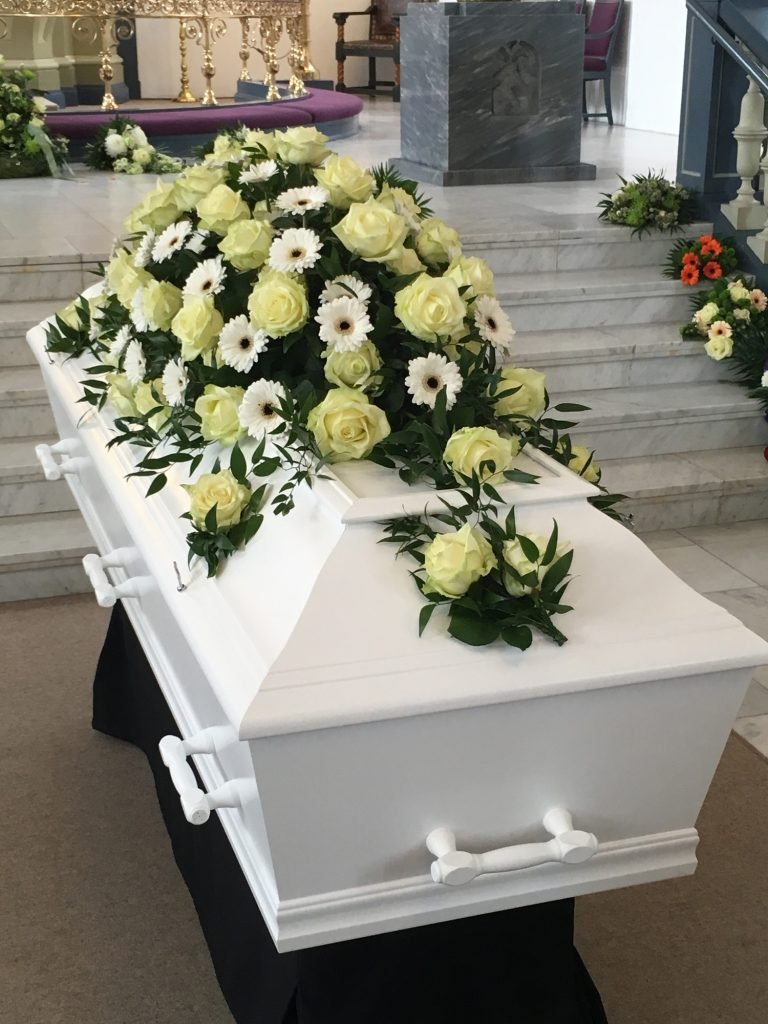 Hvid kiste med hvide og gule blomster